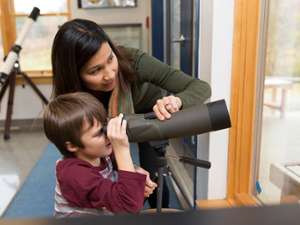woman and boy checking out a telescope