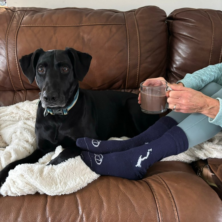 Lake George coffee mug paired with a pair of unisex silhouette of Lake George socks.  Cuddling with your pup.