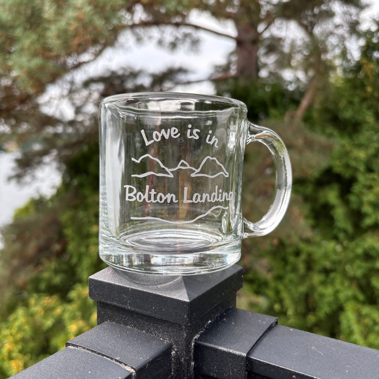 Love is in Bolton Landing text hand sand blasted over and under our lake and mountain scene on a clear Coffee Mug
