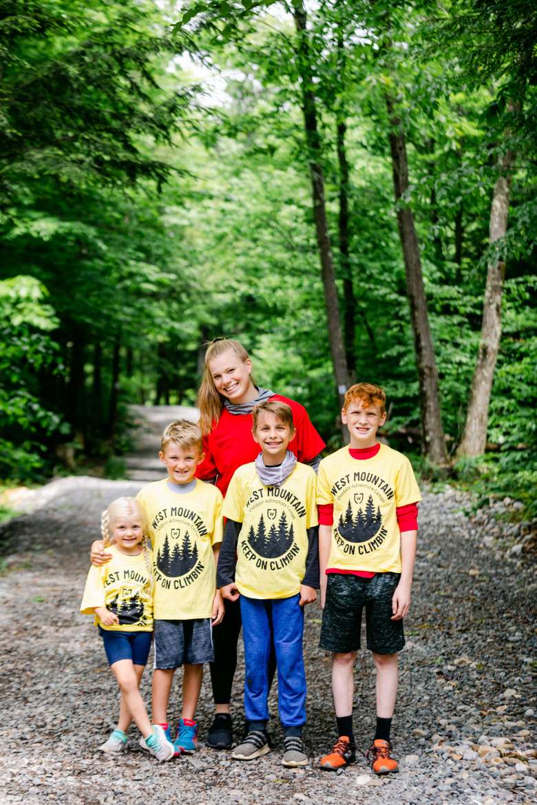 a woman and four kids wearing yellow summer camp shirts