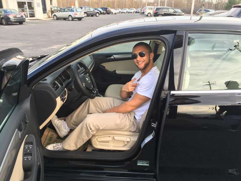 man sitting inside a car with the door open