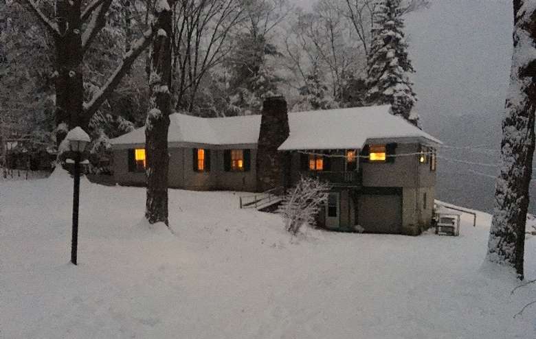 a cottage surrounded and covered by snow