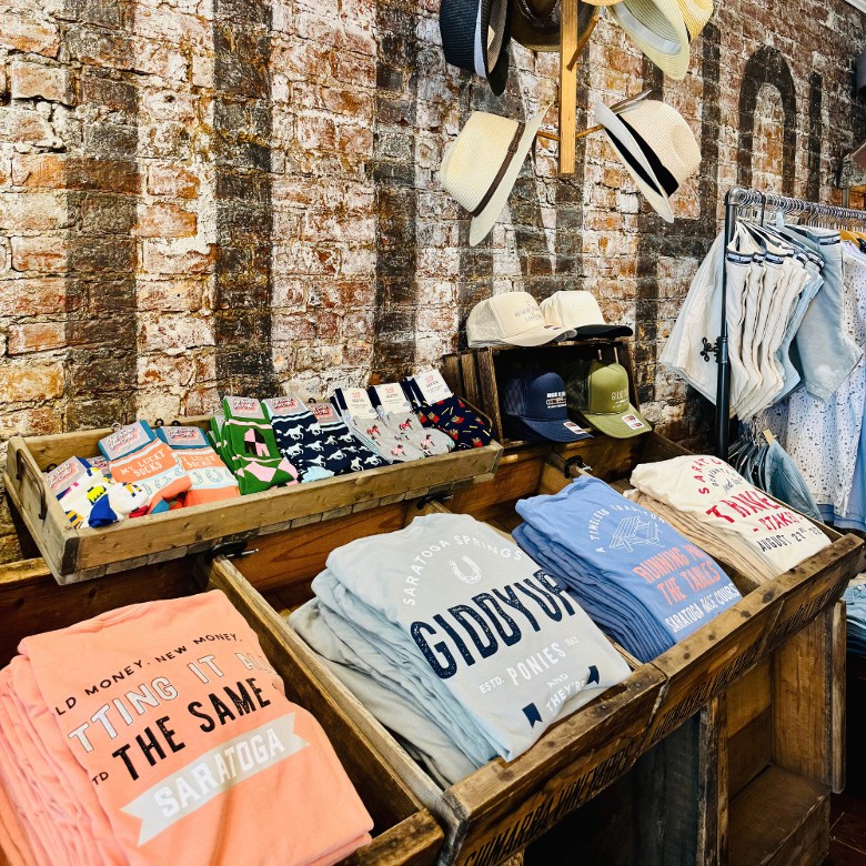 We create our own exclusive Saratoga Race Track tees and hats&mdash;designed in-house with race day vibes woven into every stitch.