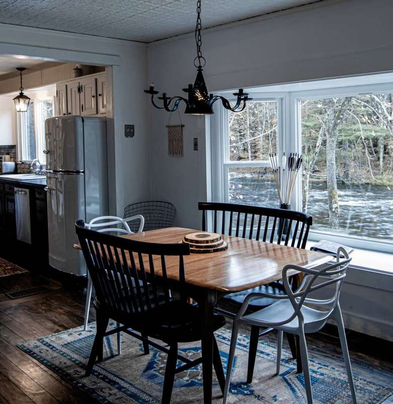 dining room with table and window view of a river warner's camp adirondack cabin rental