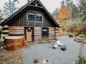 log cabin with hot tub out front