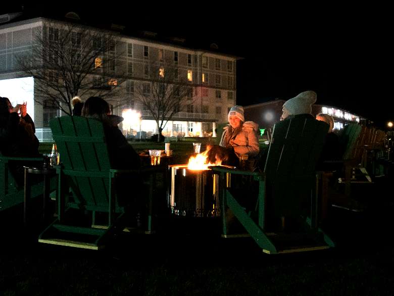 One of our lakeside firepits at night with the hotel in the background