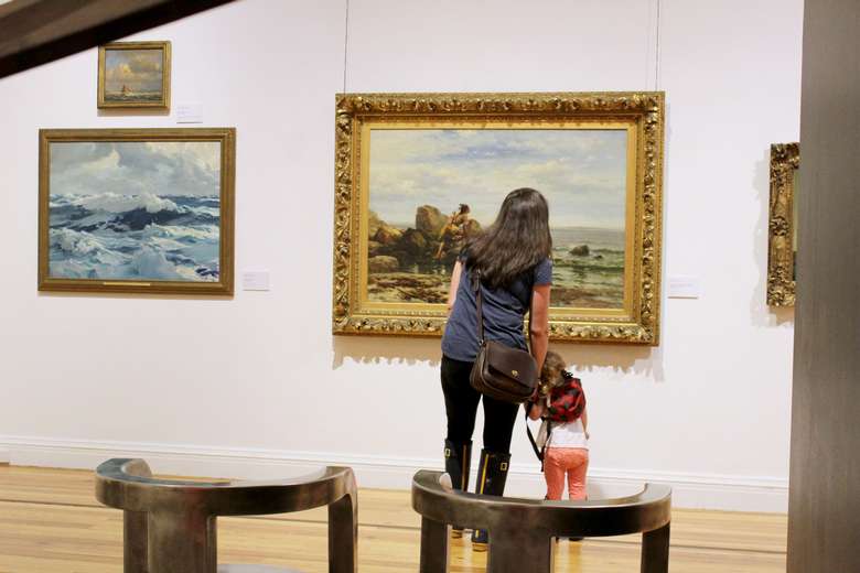 A parent and child view a painting in the galleries of the Berkshire Museum.