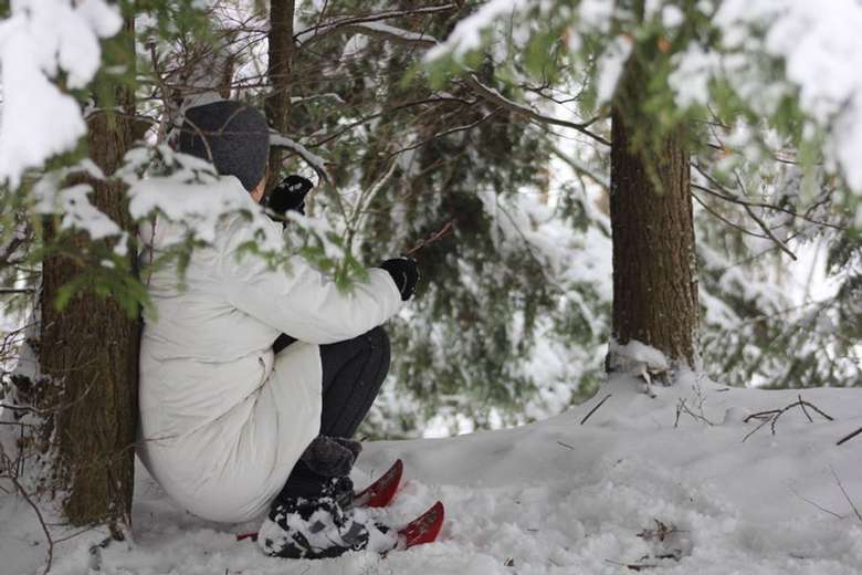 person sitting down on ground in snow