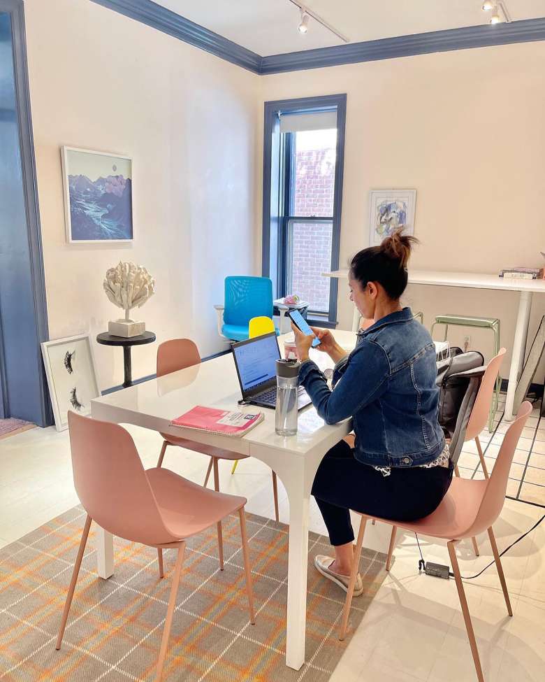 a woman seated at a desk with a laptop in a coworking room