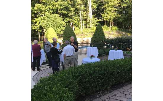 people outside in a garden area near tables