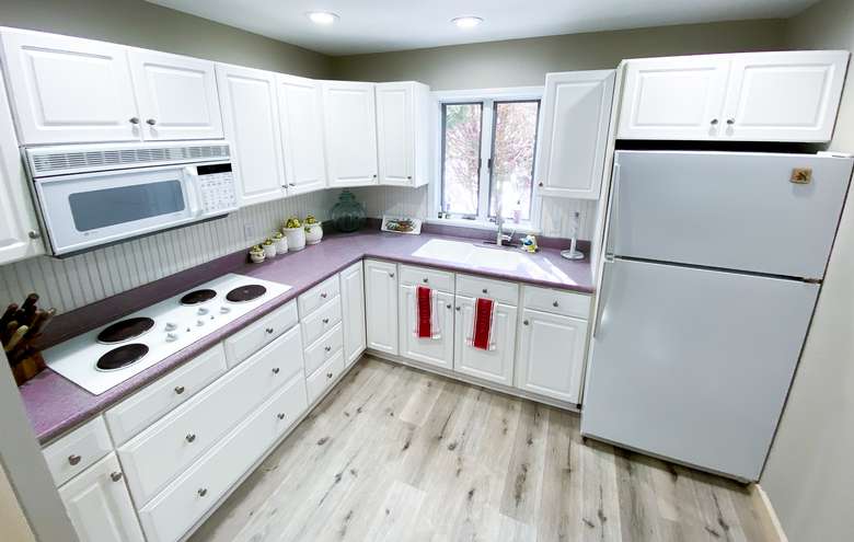 kitchen with white cabinets, a fridge, an oven, and a microwave