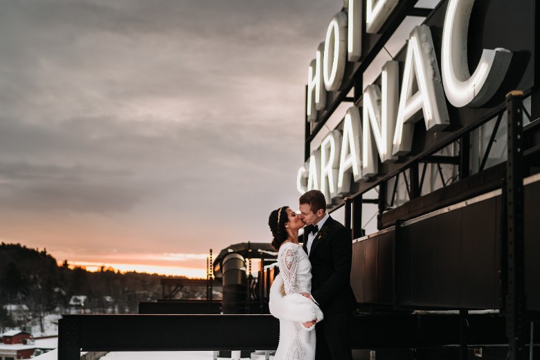 Rooftop wedding photo location at Hotel Saranac under the iconic hotel sign in Saranac Lake NY