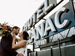 Rooftop wedding photo location at Hotel Saranac under the iconic hotel sign in Saranac Lake NY, fall foliage