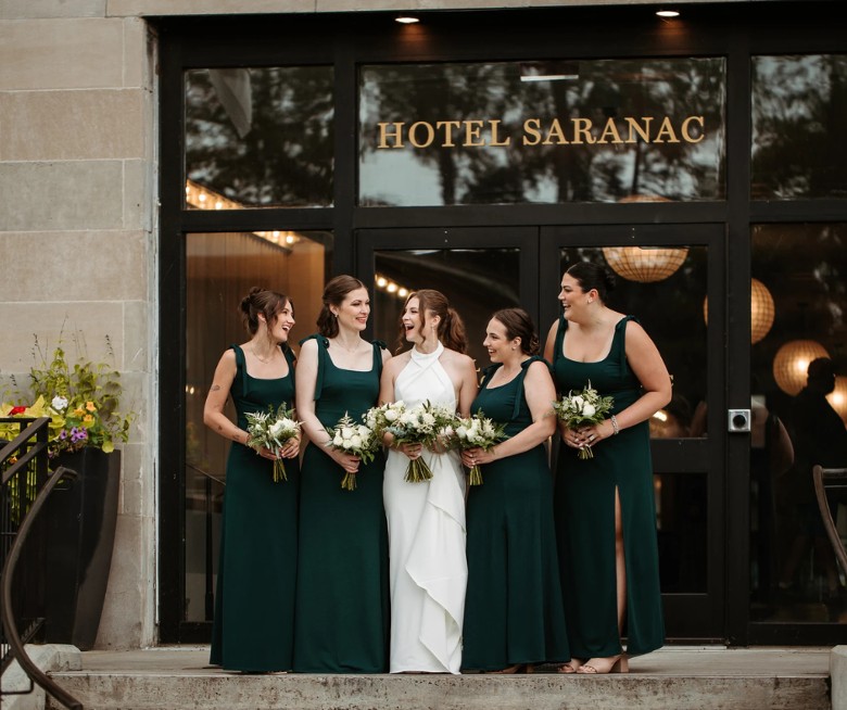 Bridal party in front of Hotel Saranac entrance sign in Saranac Lake NY