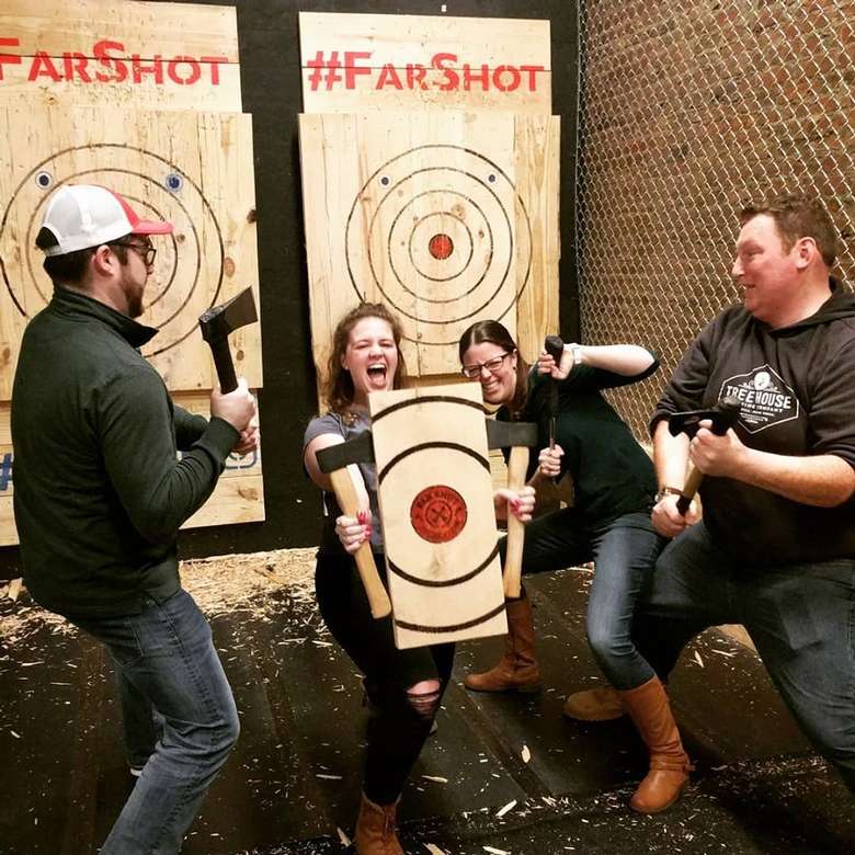 people at axe throwing place posing