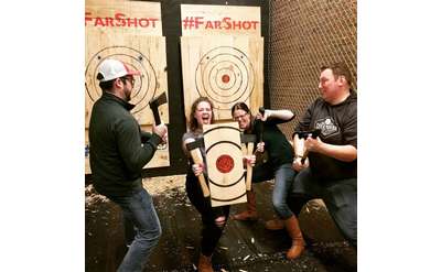 people at axe throwing place posing