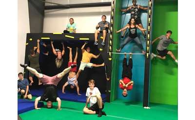 group of people on ninja obstacles in a gym