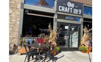 table and chairs outside a building with a sign that reads craft on 9