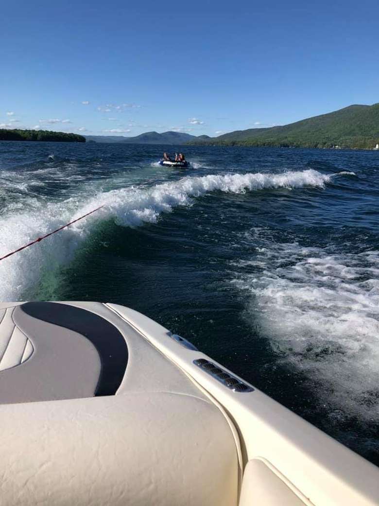 people tubing behind a boat on a lake