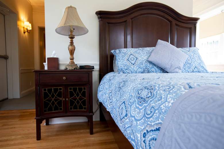 bed with blue quilted comforter and wooden night stand