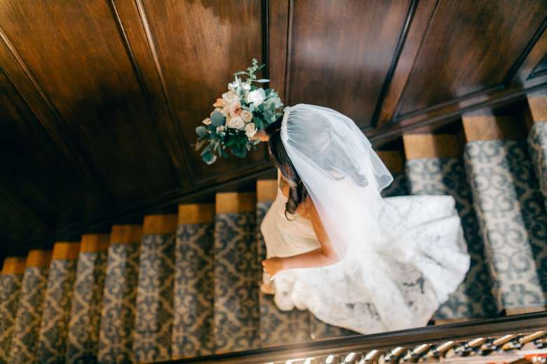 bride in a wedding dress walking down the stairs