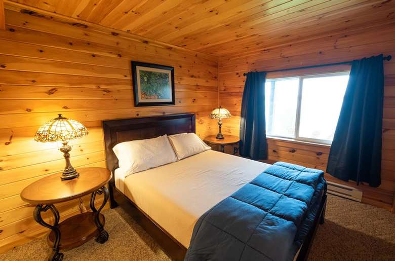 bed in bedroom, wood panel walls