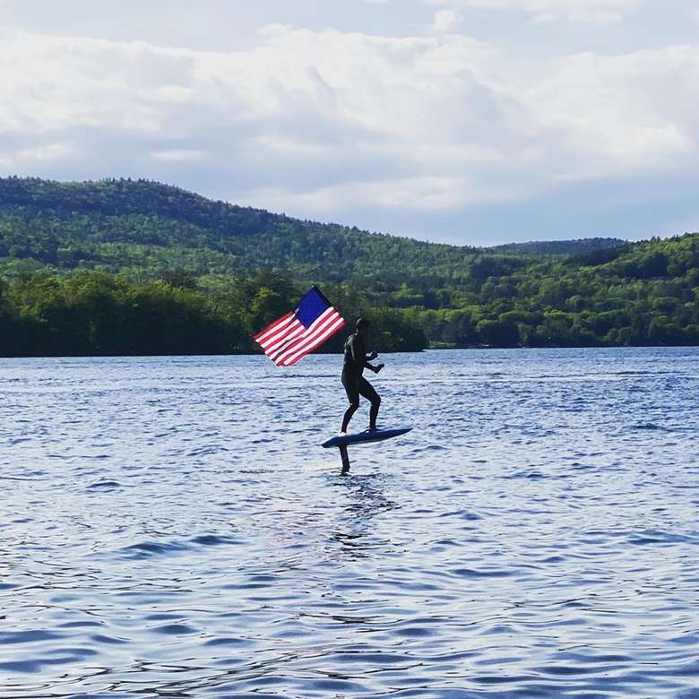 an efoil rider holding an american flag