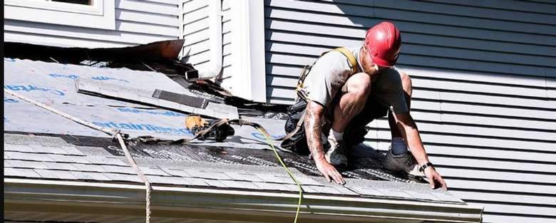 man attaching roof shingles