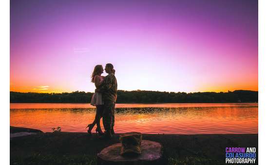 couple embrace at sunset by water