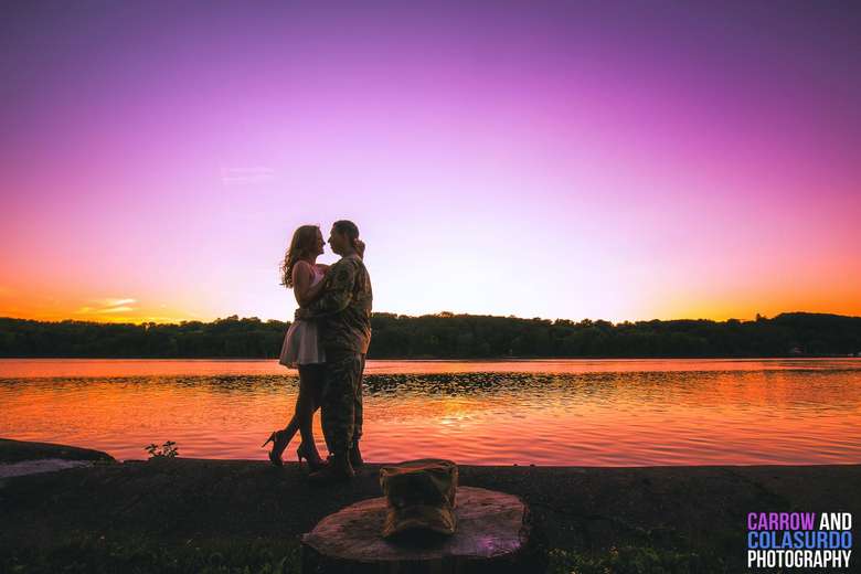 couple embrace at sunset by water
