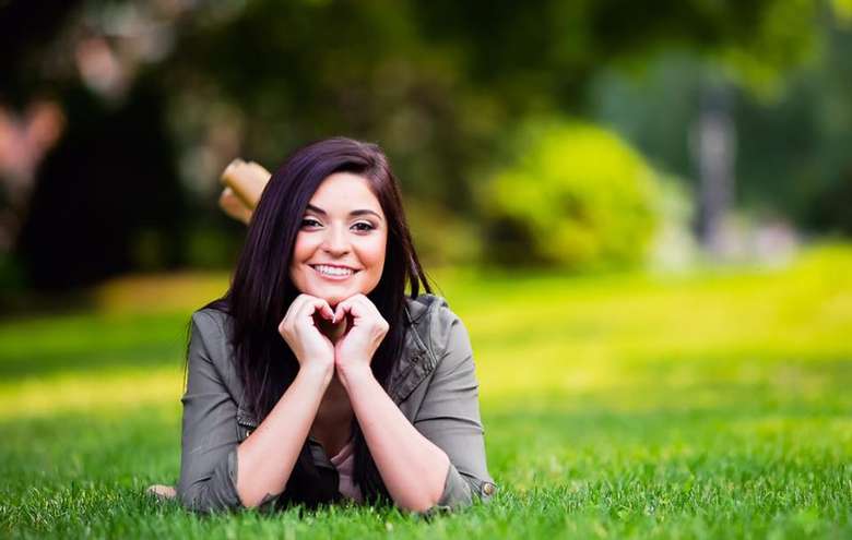 smiling woman posing on grass