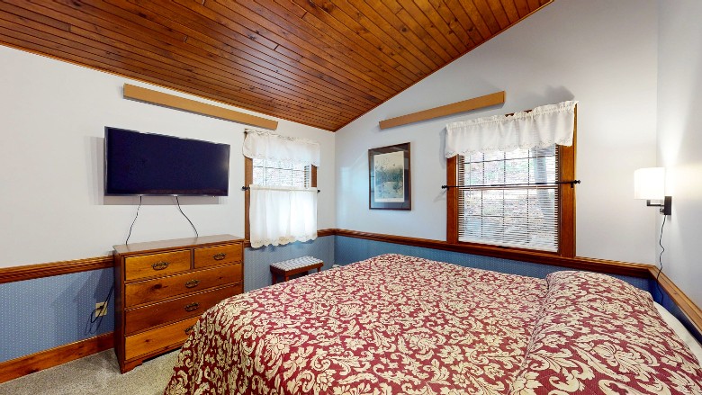 Bedroom with a king size bed and a tv on the wall