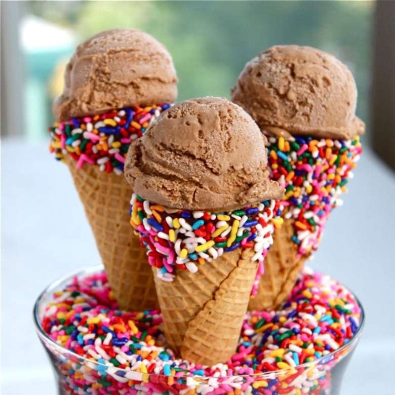 three sugar cones with chocolate ice cream and rainbow sprinkles
