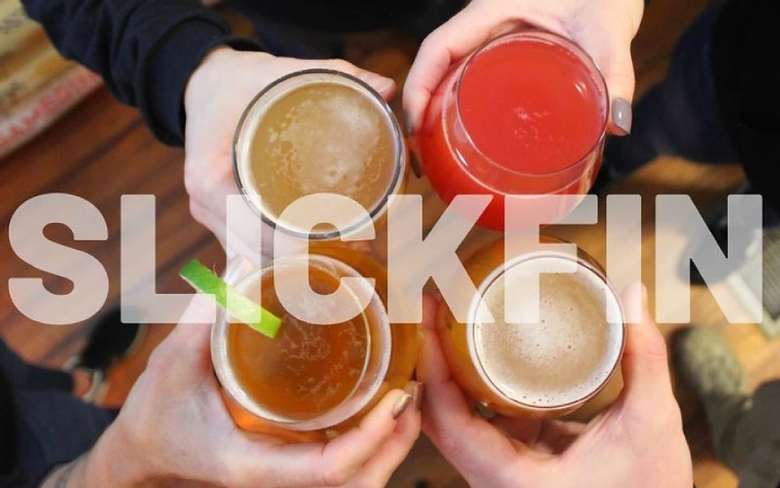 four people holding glasses of craft beer