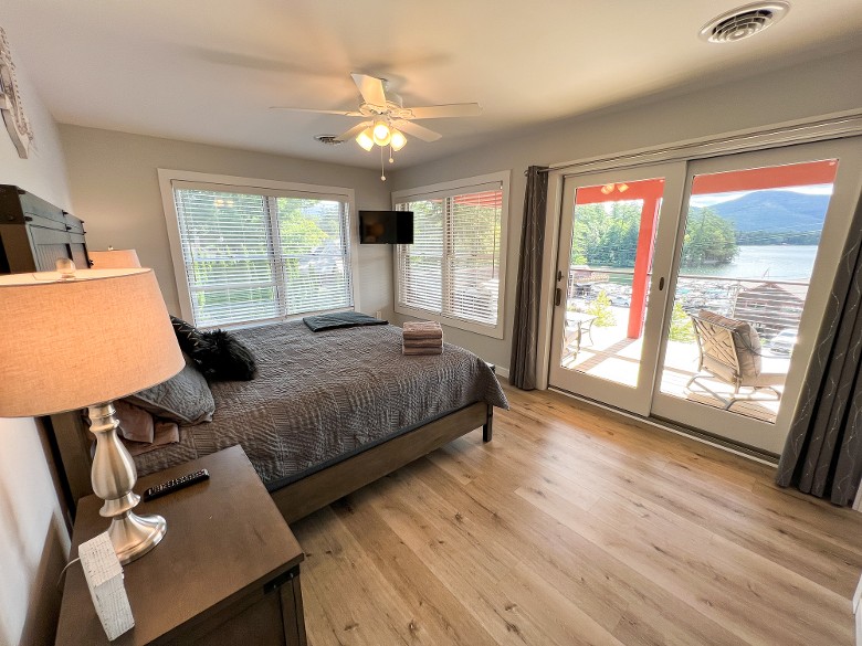 The primary bedroom features a king bed with access to a balcony with lake views.
