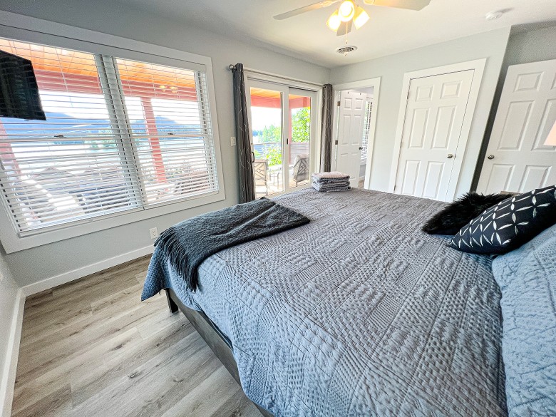 The primary bedroom features a king bed with access to a balcony with lake views