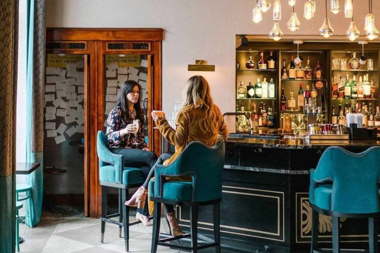 Handcrafted cocktail in the historic Great Hall at Hotel Saranac before dinner