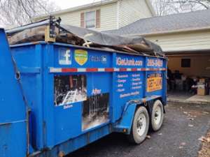 a large blue junk truck outside a house