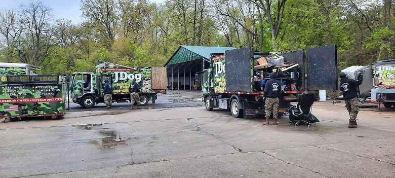 two JDog Junk Removal trucks and a dumpster