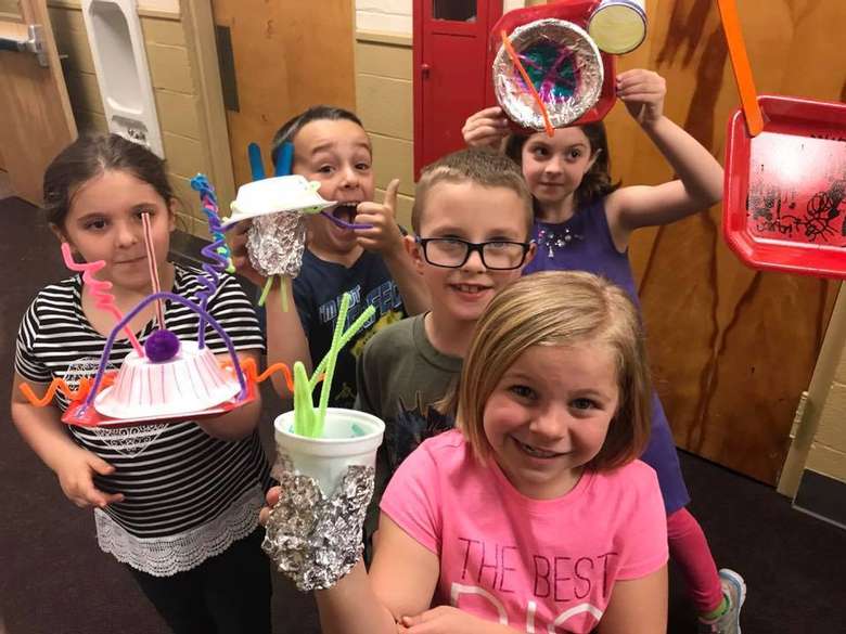 kids holding up crafts