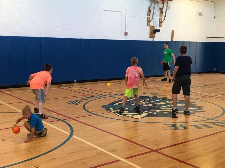 kids playing dodgeball in a gym
