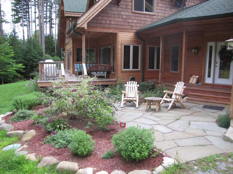 a patio area by a house and garden