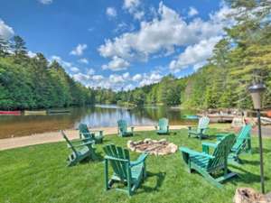 green chairs around fire pit by a lake