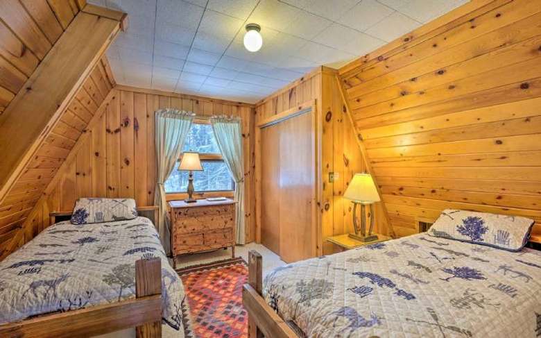 bedroom with wooden walls and two beds