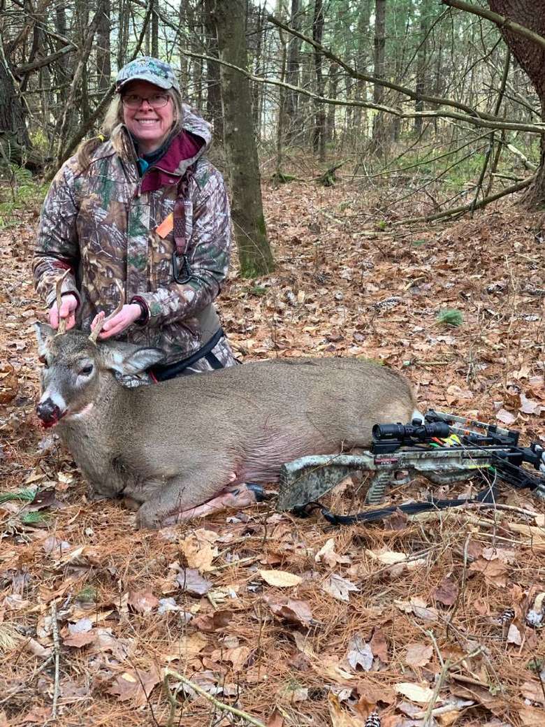 Woman with a harvested buck.