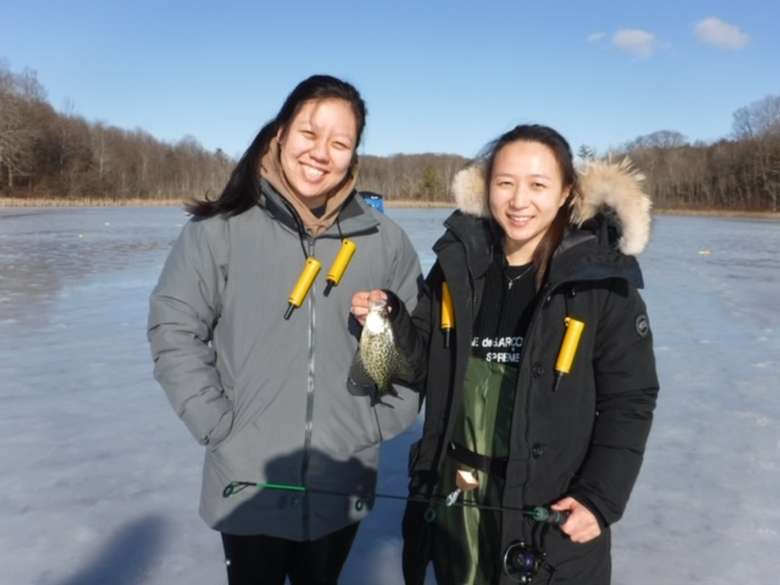 These ladies tried ice fishing for the first time, and a nice crappie was brought up through the hard water hole!