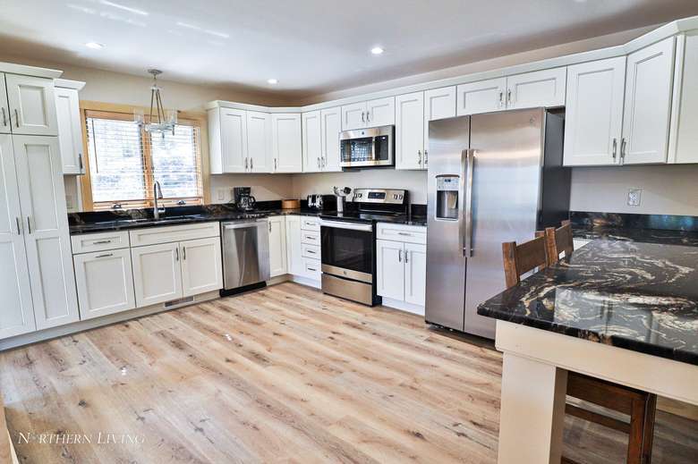 large kitchen with cabinets, a fridge, a sink, and a table
