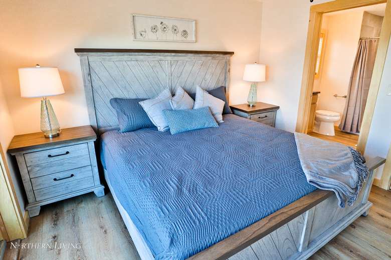 a bedroom with blue gray blankets on the bed