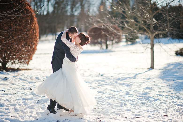bride and groom embrace in the snow