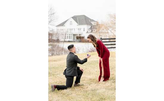 man in suit proposing to woman in red dress